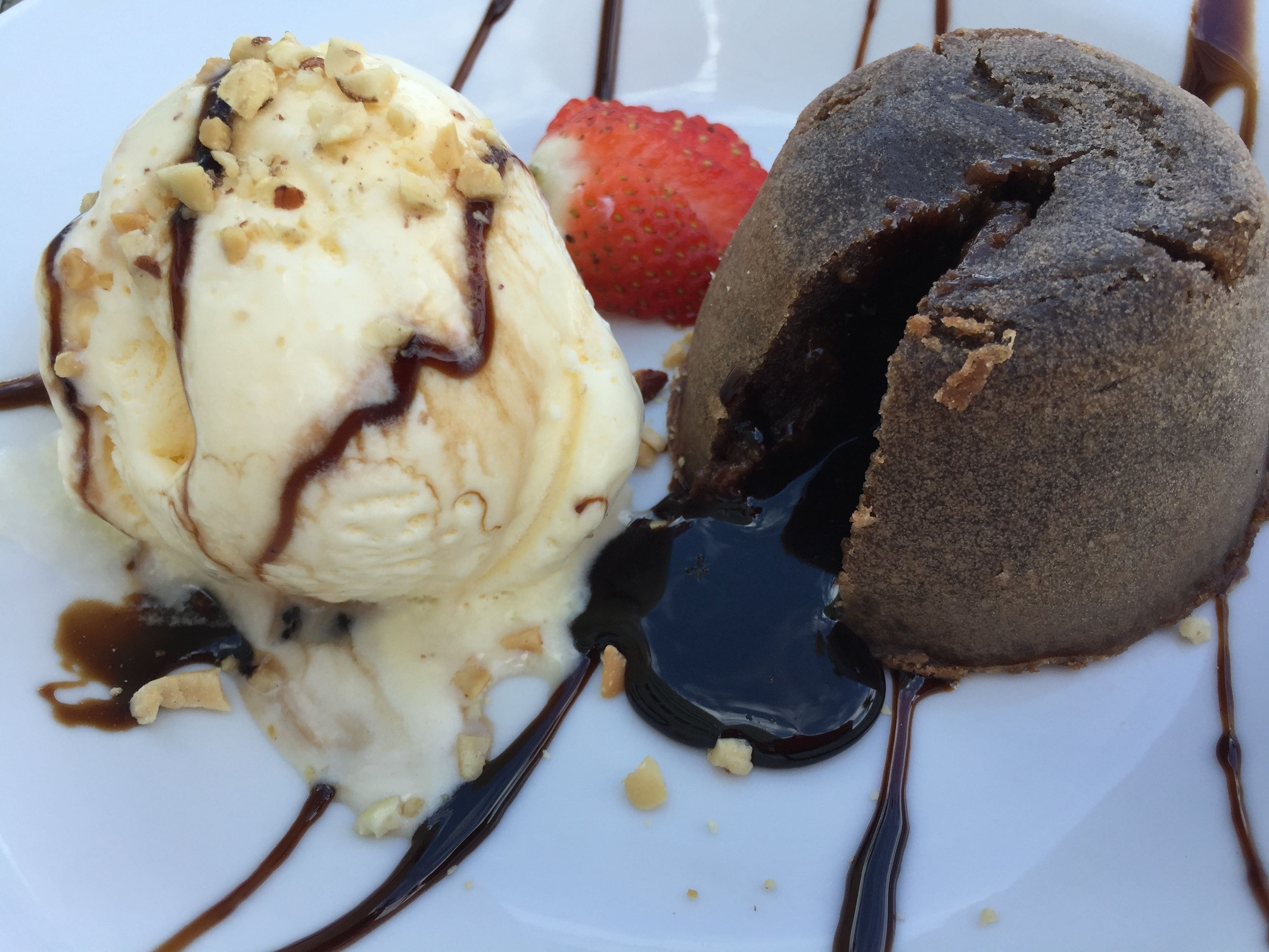 A dessert plate with ice cream and a chocolate lava cake.