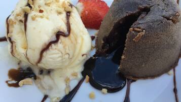 Un plato de postre con helado y un pastel volcán de chocolate.