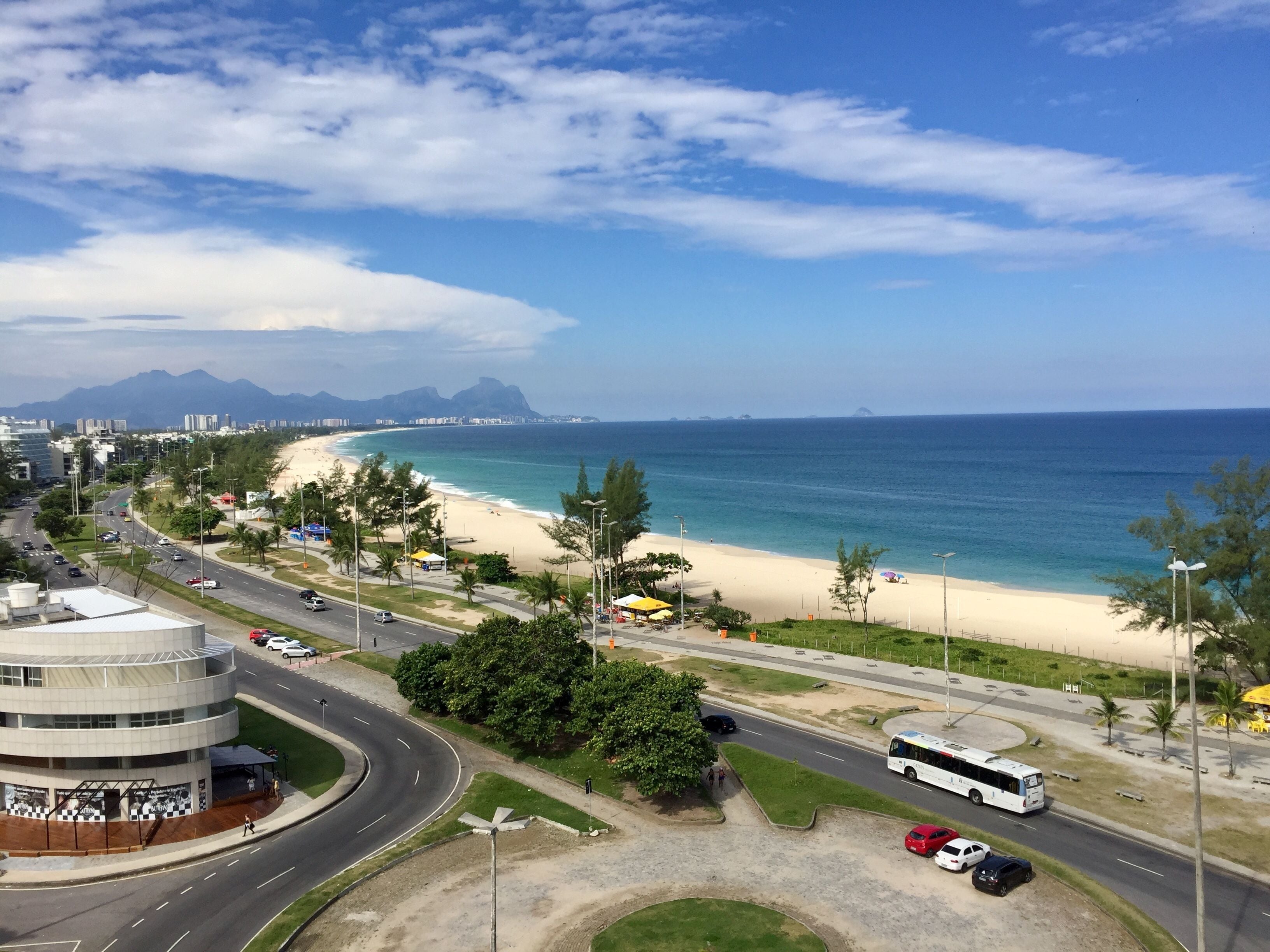 Un paisaje urbano costero con playa, carreteras y una glorieta.