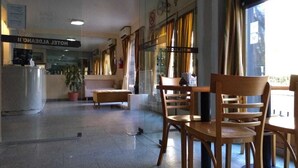 A hotel lobby with a reception desk, seating area, and large windows. - Aldeano II (Buenos Aires)