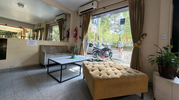 A hotel lobby with a sofa, a table, and a potted plant. - Aldeano II (Buenos Aires)