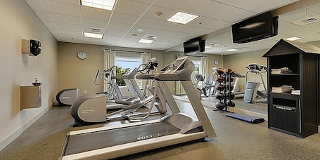 A fitness center with treadmills, elliptical machines, and a weight station.