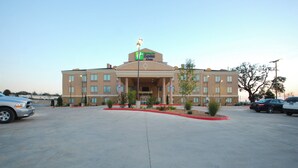 A hotel with a central entrance, multiple windows, and a parking lot. - Holiday Inn Express & Suites Gonzales by IHG (Gonzales)