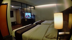 A hotel room with two beds, a television, and a desk with a computer.