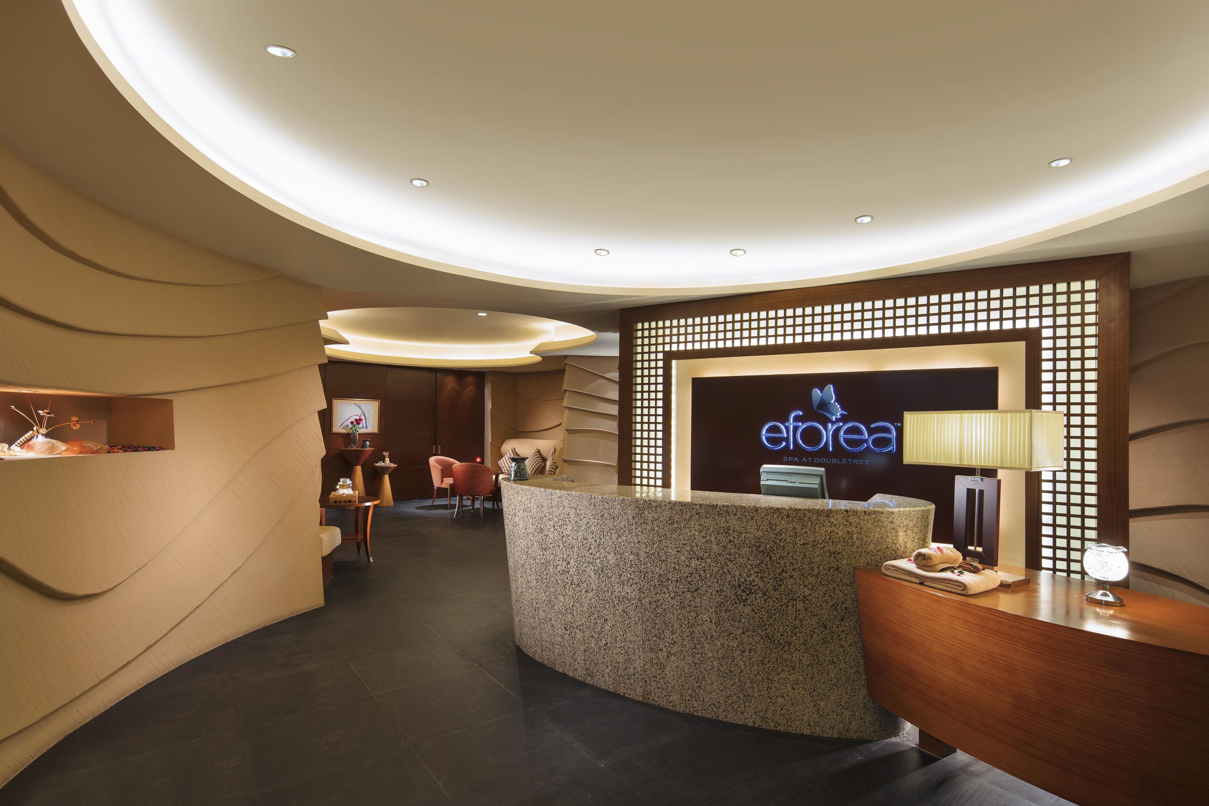 A reception area with a reception desk, a seating area with chairs, and a wall-mounted sign.