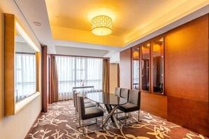 A conference room with a round table, four chairs, and a large mirror on one wall. - DoubleTree by Hilton Hotel Shenyang (Shenyang)
