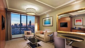 A hotel room with a city view, a sofa, a coffee table, a chair, a dining table, and a TV. - DoubleTree by Hilton Hotel Shenyang (Shenyang)