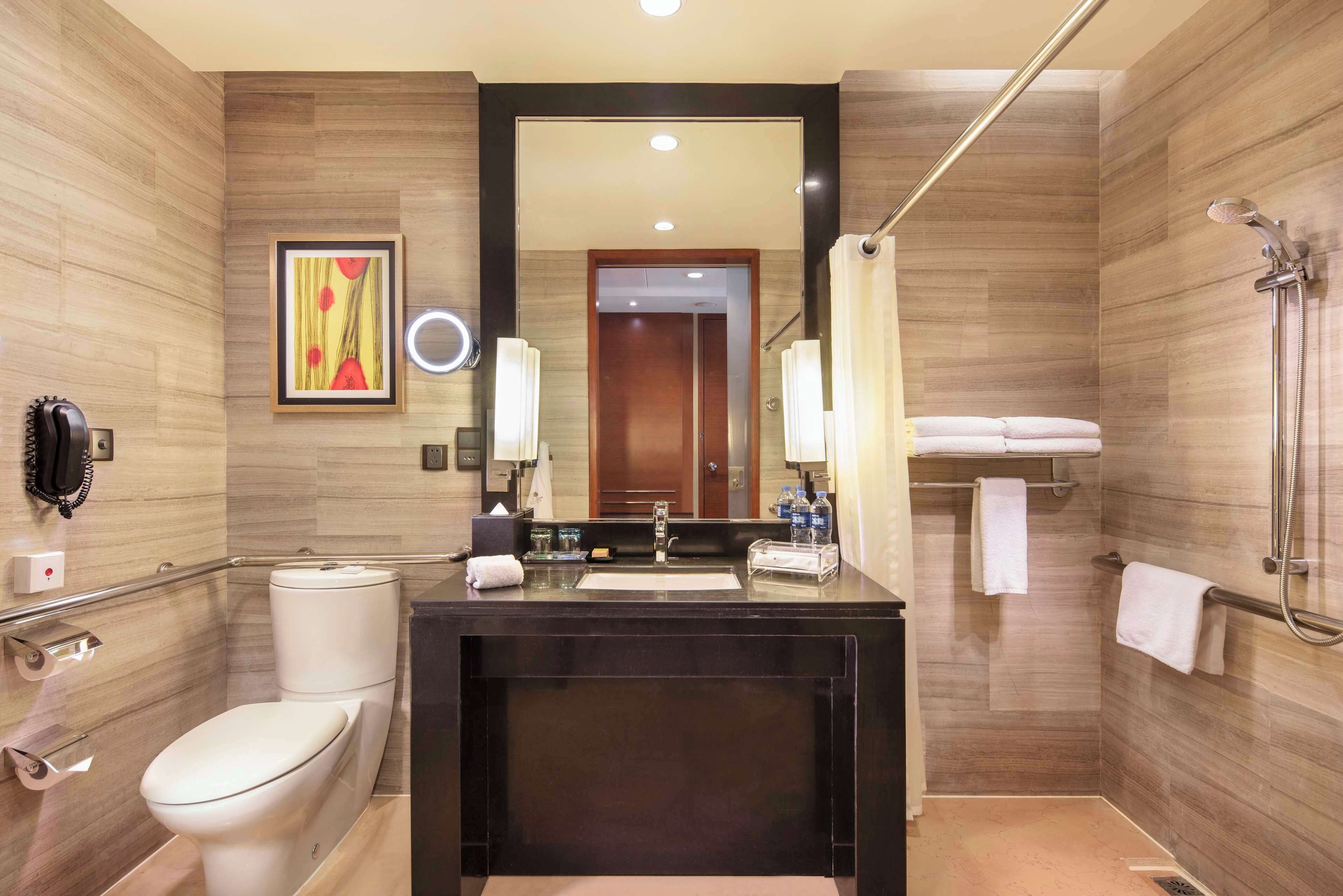 A modern bathroom with a toilet, sink, and shower.