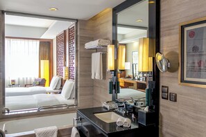A hotel room with a large bed, a bathroom with a black sink and mirror, and a view of the outside. - DoubleTree by Hilton Hotel Shenyang (Shenyang)