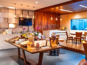 A modern hotel breakfast area with a buffet table, seating, and a view of the city. - The Paragon Hotel Mexico City Santa Fe By Accor (Mexico City)