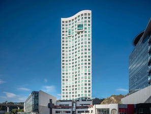 A tall, modern building with a grid of windows, surrounded by other contemporary structures. - The Paragon Hotel Mexico City Santa Fe By Accor (Mexico City)