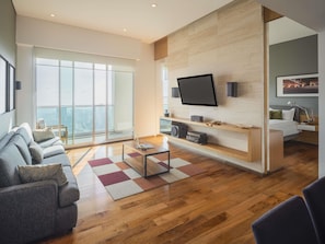 A modern living room with a large TV, wooden flooring, and a sofa. - The Paragon Hotel Mexico City Santa Fe By Accor (Mexico City)