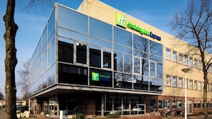 A modern building with a glass facade, a Holiday Inn Express sign, and a clear blue sky. - Holiday Inn Express Amsterdam - South by IHG (Amsterdam)