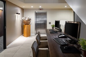 A modern office space with a desk, computer, keyboard, mouse, and a plant. - Holiday Inn Express Amsterdam - South by IHG (Amsterdam)