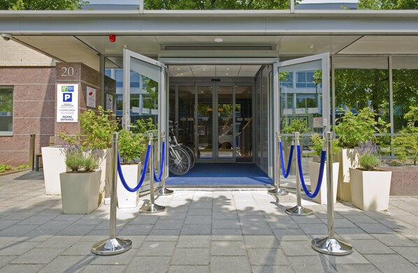 A hotel entrance with a blue carpet, glass doors, and a number 20 sign. - Holiday Inn Express Amsterdam - South by IHG (Amsterdam)