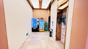 A corridor with vending machines, a trash bin, and a poster on the wall. - Holiday Inn Express Changzhou Center by IHG (Changzhou)