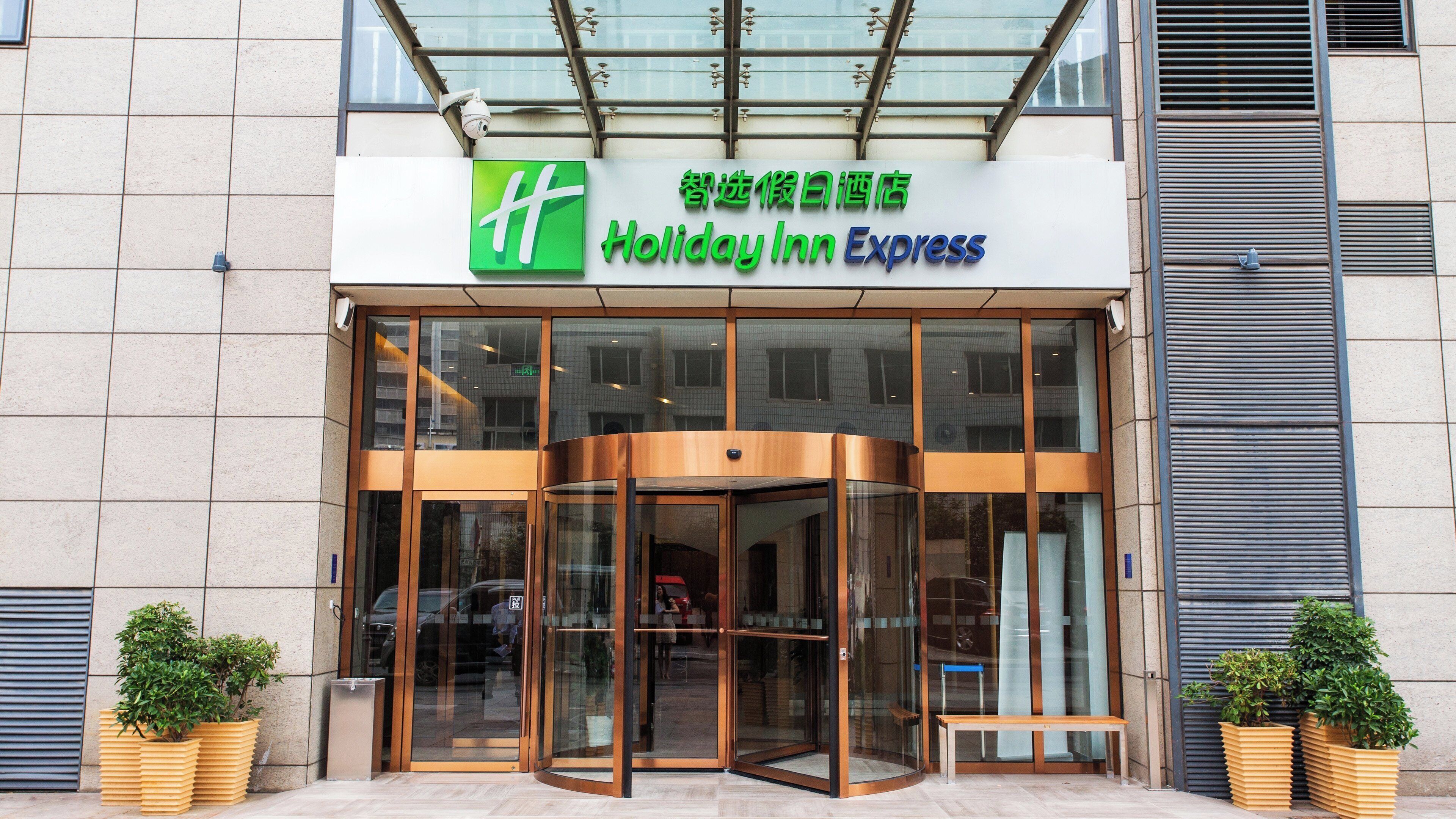 A Holiday Inn Express with a glass entrance and a revolving door.