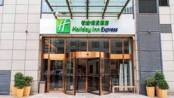 A Holiday Inn Express with a glass entrance and a revolving door.