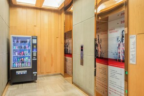 A hallway with a vending machine, wooden panel walls, and a directory sign. - Holiday Inn Express Changzhou Center by IHG (Changzhou)