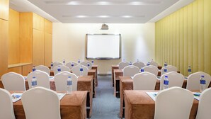 A conference room with tables, chairs, and a projector screen. - Holiday Inn Express Changzhou Center by IHG (Changzhou)