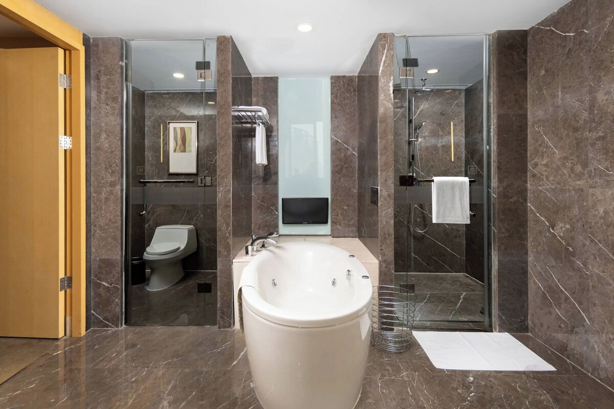Ein modernes Badezimmer mit einer großen Badewanne, einer Toilette und einer Duschkabine.