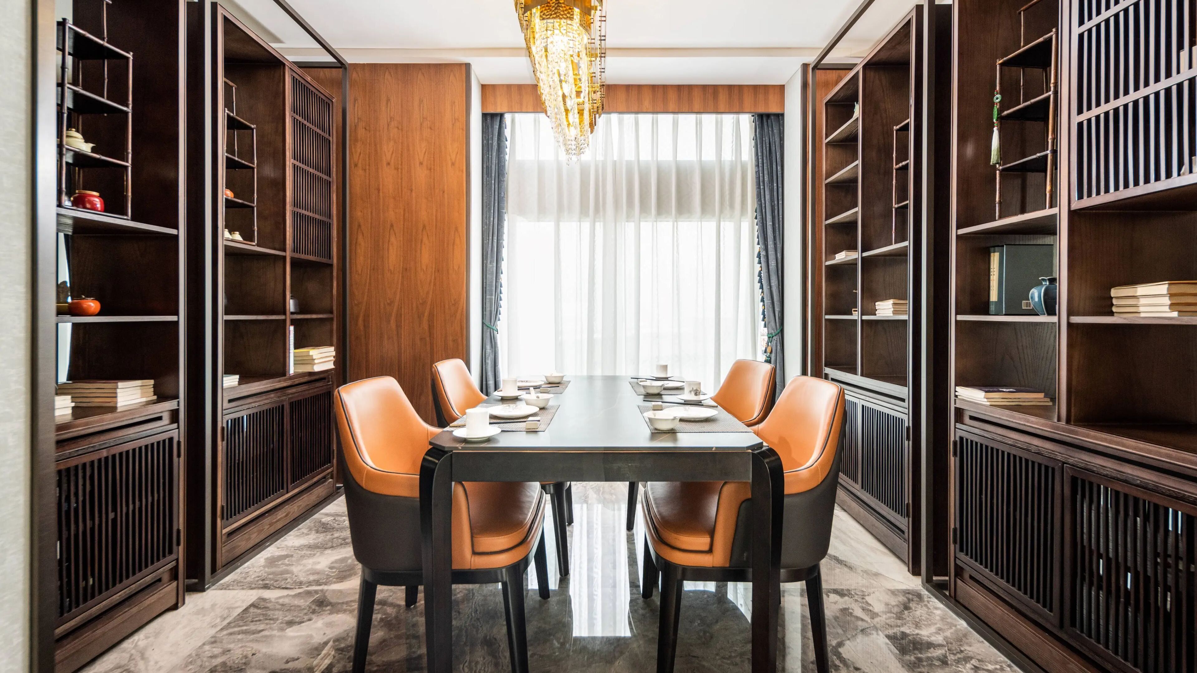 A dining area with a long table, six chairs, and bookshelves on either side.