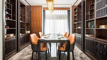 Un comedor con una mesa larga, seis sillas y estanterías a ambos lados.