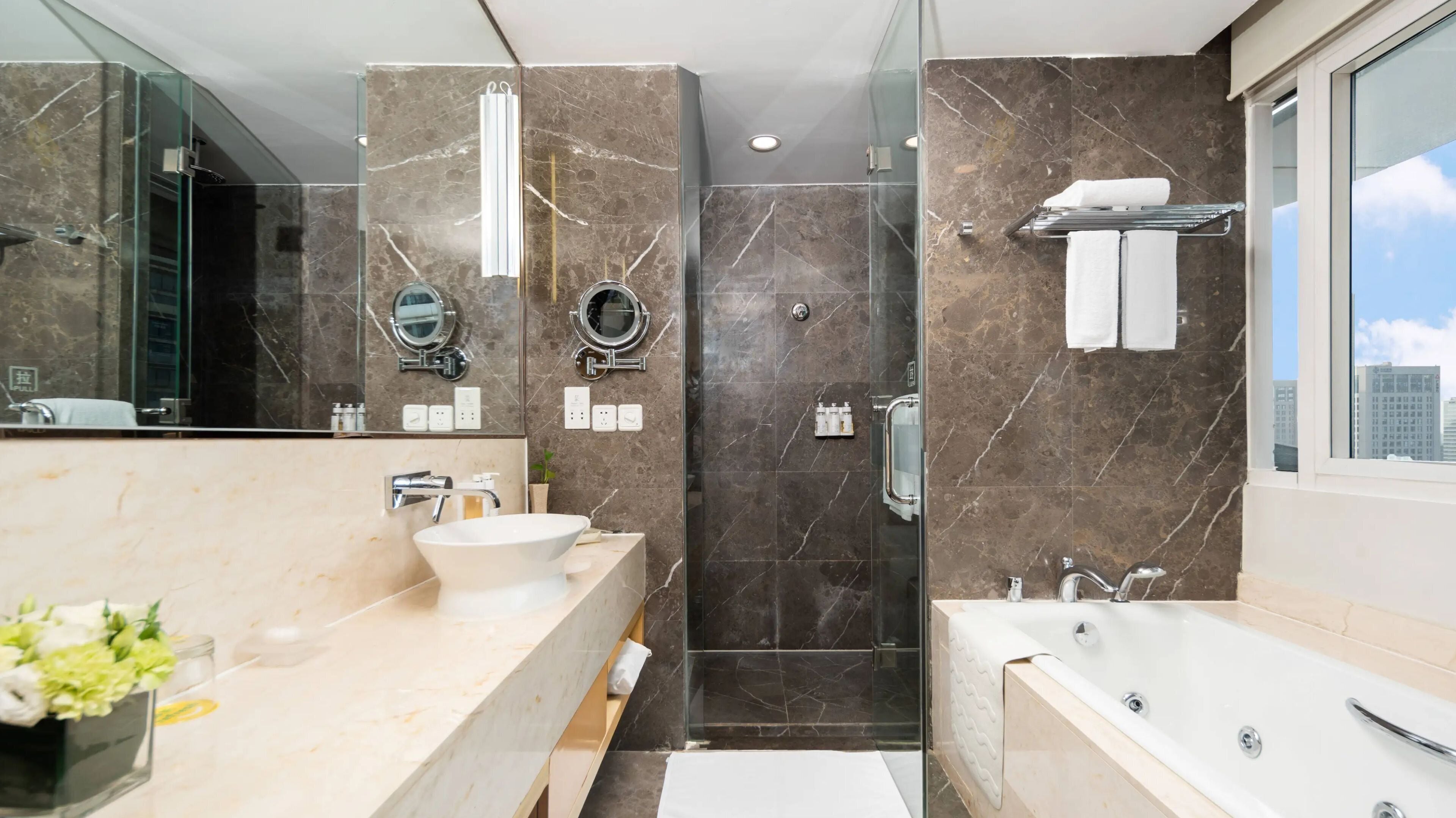 Un baño moderno con un espejo grande, una bañera y zona de ducha.