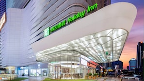 Un hôtel Holiday Inn doté d’une architecture moderne, caractérisé par une façade en verre incurvée et un hall d’entrée spacieux.