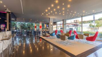 A modern interior with a seating area, large windows, and a view of the outside.