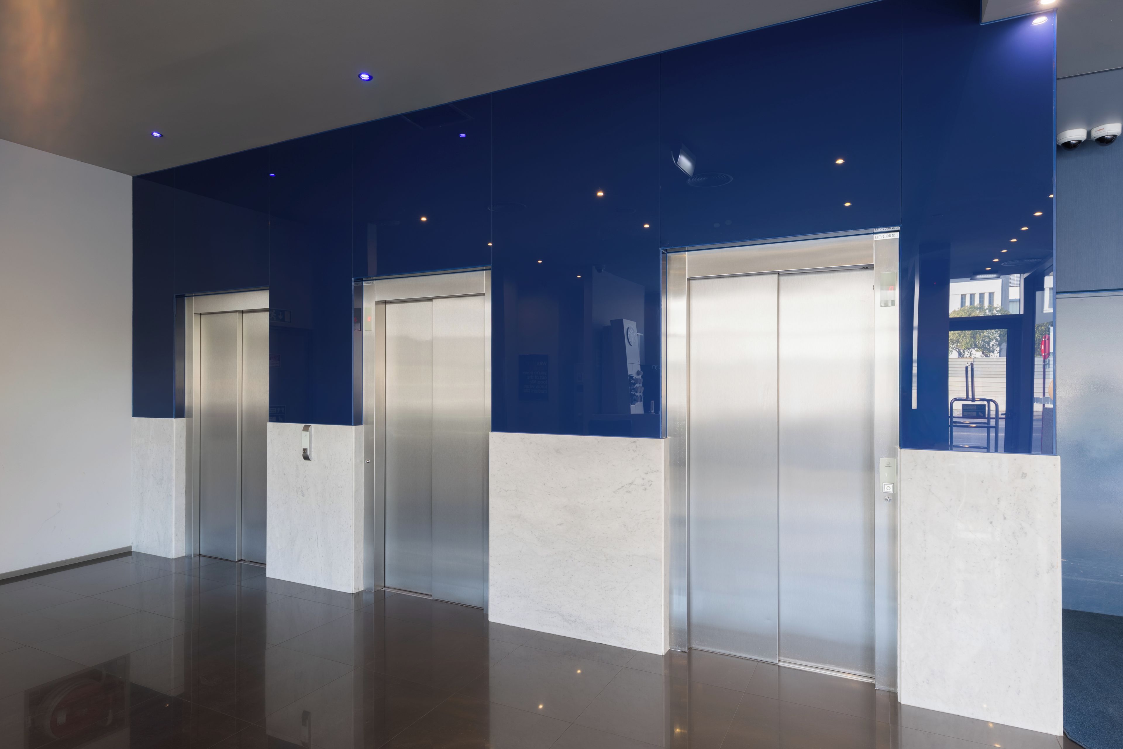 A modern elevator area with metallic doors and a reflective floor.