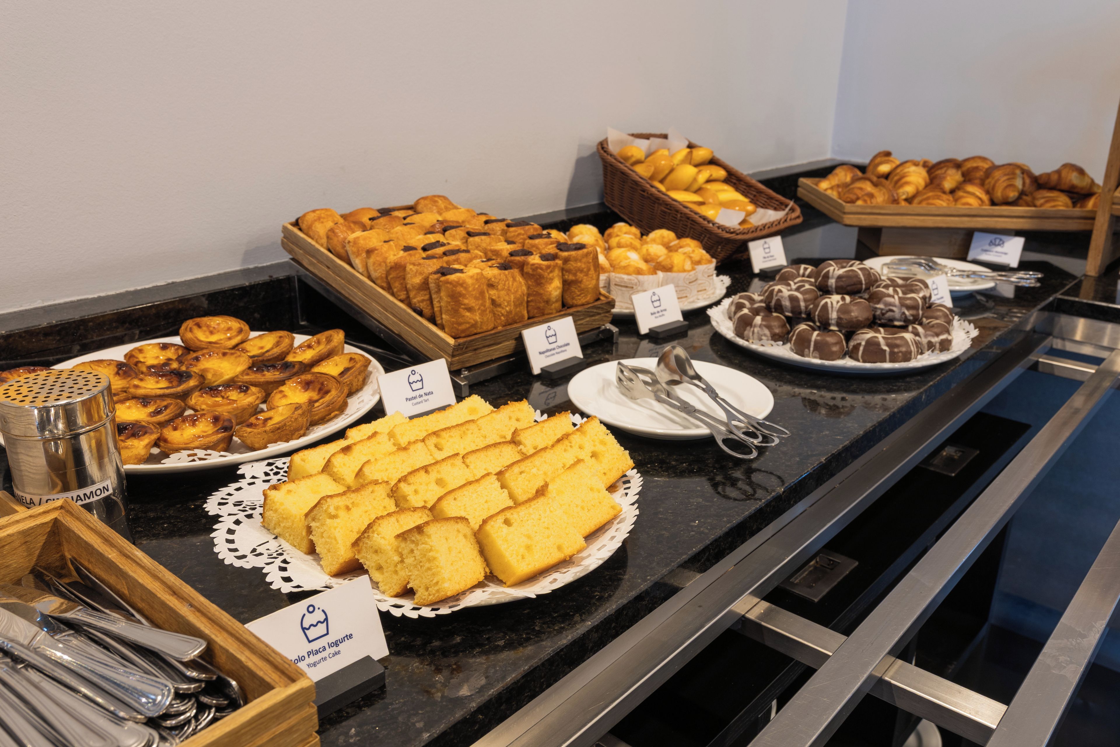 Un bufé con diversas opciones de panadería, incluyendo pasteles, tartas y pan.