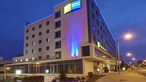 Een modern hotel met een opvallend Holiday Inn Express bord, grote ramen en een goed verlichte ingang.