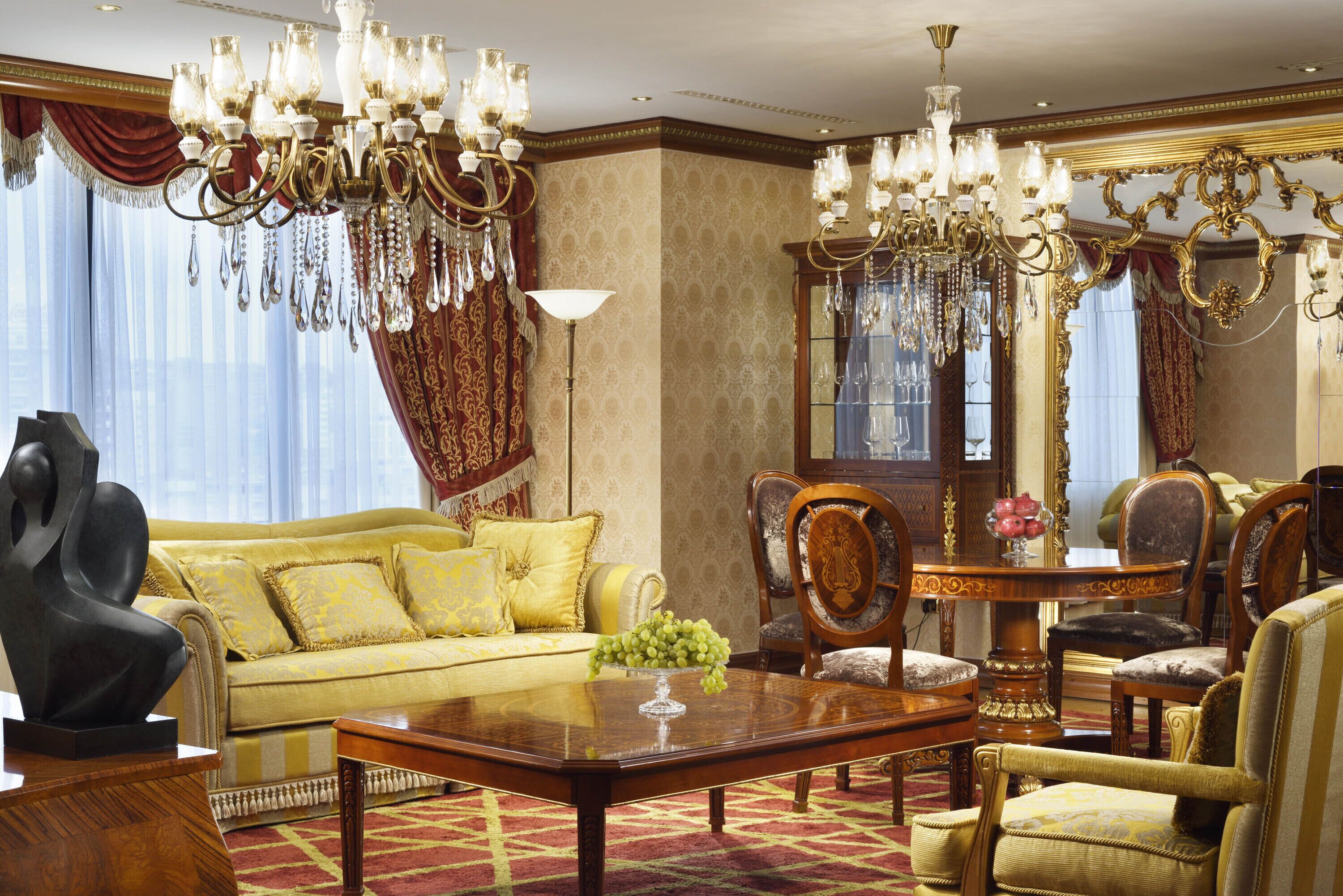 Ein luxuriöses Zimmer mit einem gelben Sofa, aufwendigen Kronleuchtern und klassischem Holzmöbel.