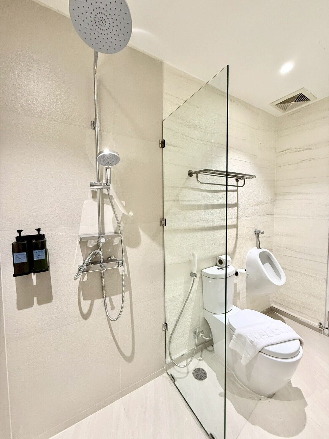 A modern bathroom with a glass-enclosed shower, a toilet, and a bidet.
