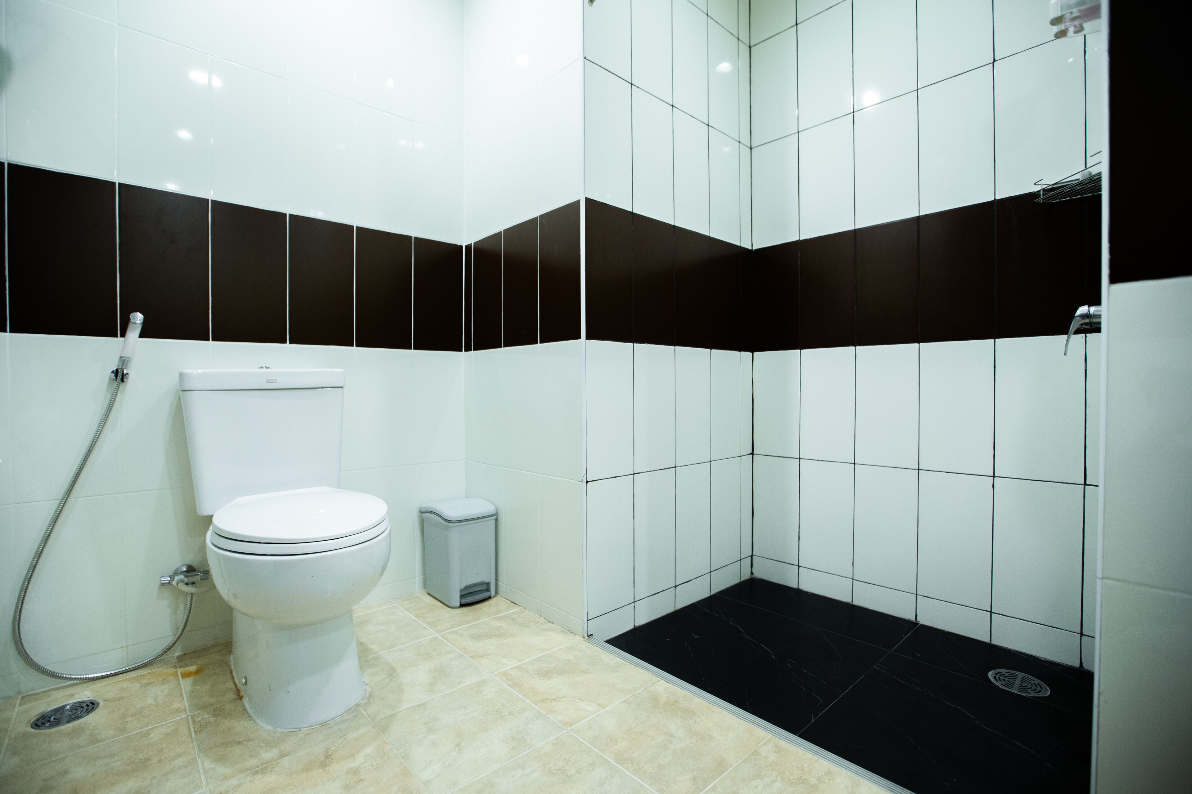 Une salle de bain équipée de toilettes, d’une douche et d’une poubelle.