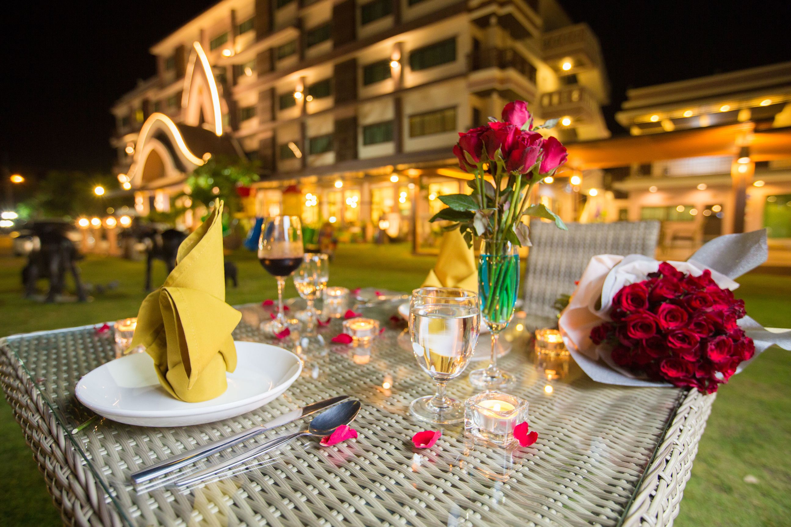 A dining table set outdoors with a view of a building in the background.