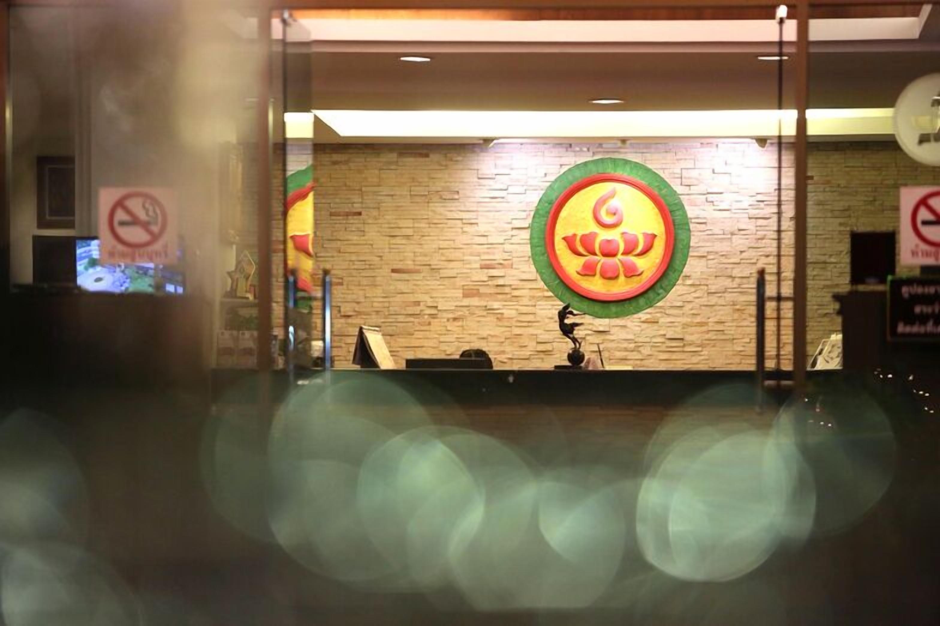 Un espace d’accueil avec un mur en bois et un grand logo circulaire.