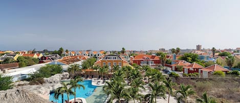 Un resort con piscina, palmeras y edificios de colores.