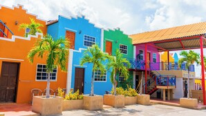 A colorful building with a red staircase and a balcony. - The Ritz Village Hotel  (Willemstad)