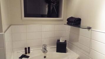 A bathroom with a white sink, a mirror, and a towel rack.