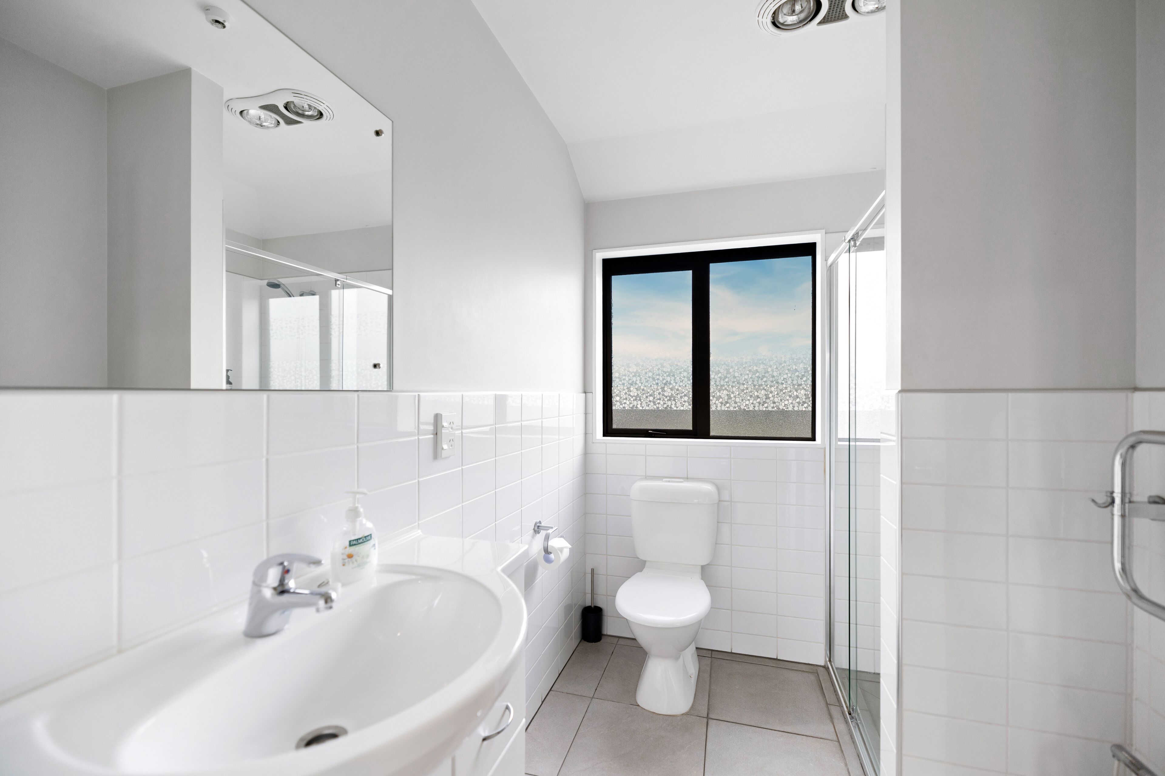 Un baño moderno con un lavamanos grande, inodoro y ventana con vistas.