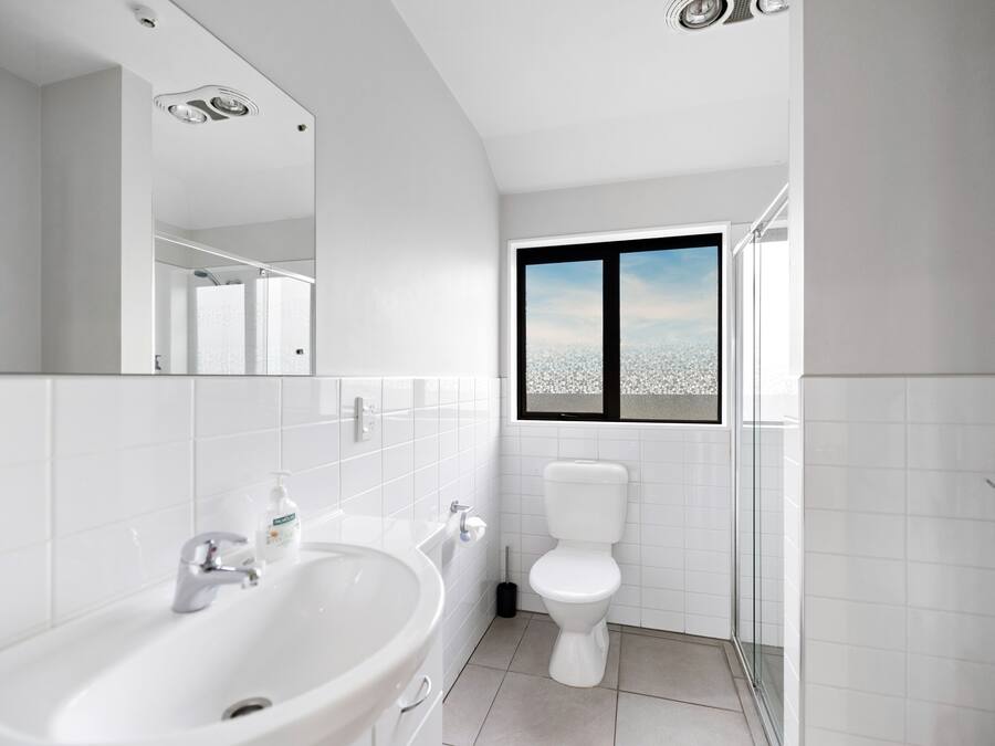 Un baño moderno con un lavamanos grande, inodoro y ventana con vistas.