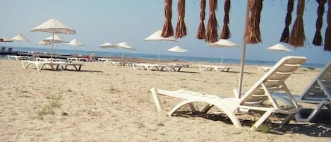 Een privéstrand, ligstoelen aan het strand