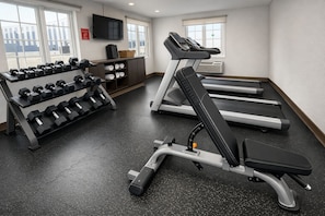 A gym with treadmills, a bench press, and dumbbells. - Extended Suites Monterrey Aeropuerto (Apodaca)
