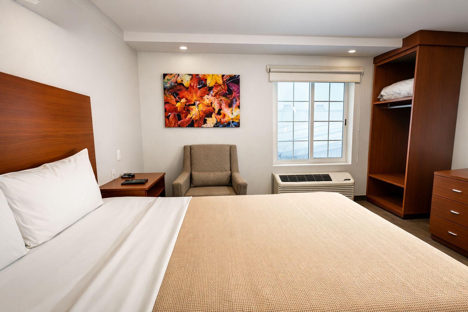 Habitación de hotel con cama, una silla, armario, calentador y ventana con persianas.