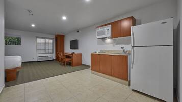 Una cocina moderna con microondas, refrigerador y armarios de madera.