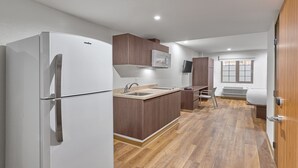 Una cocina compacta con un refrigerador blanco, armarios de madera, un microondas integrado y una ventana con vistas.