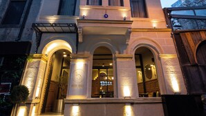 A multi-story hotel with a grand entrance, illuminated by exterior lights, and featuring a prominent arched doorway. - Balo (Istanbul)