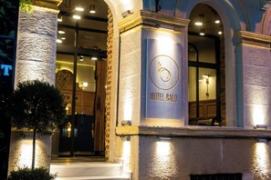Hotellin sisäänkäynti, jossa on kyltti, jossa lukee ”HOTEL BALO”, kivinen julkisivu ja portaikko, joka johtaa aulaan.